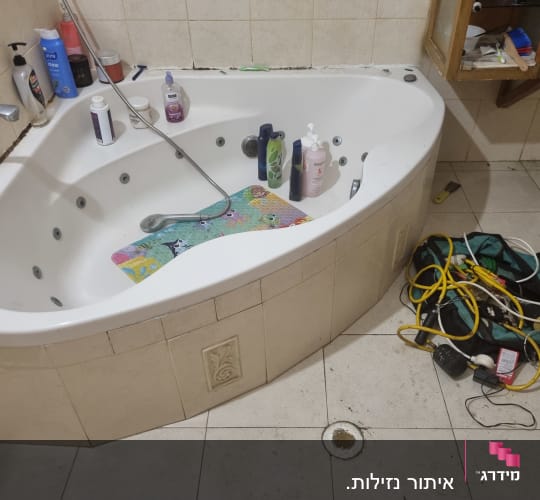 כלים וכלי עבודה ליד אמבטיה בחדר רחצה